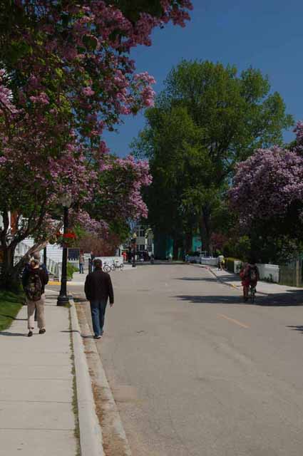 Pedestrians, both local and tourists, stroll down Huron Street on Mackinac Island